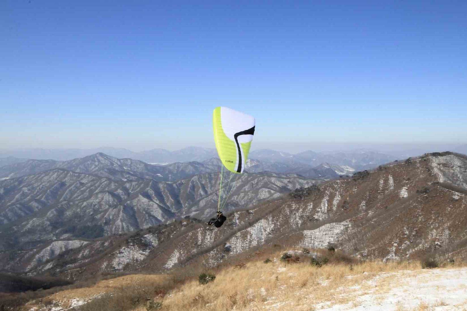 Gehuurde paragliding set in volle vlucht boven bergen in zuid korea